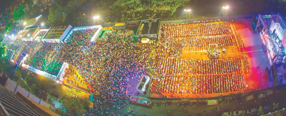 A panoramic aerial view of an enormous festival crowd