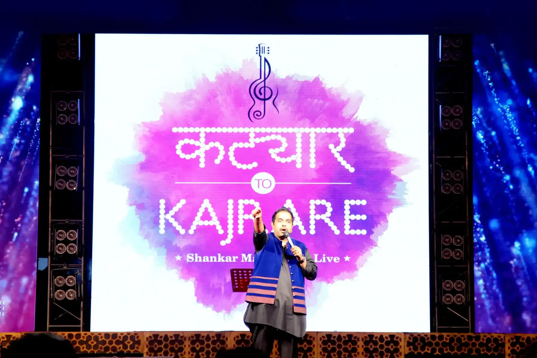 A live concert performance with a large LED screen backdrop