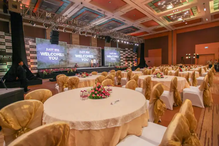 An event hall with LED branding and gold themed guest tables