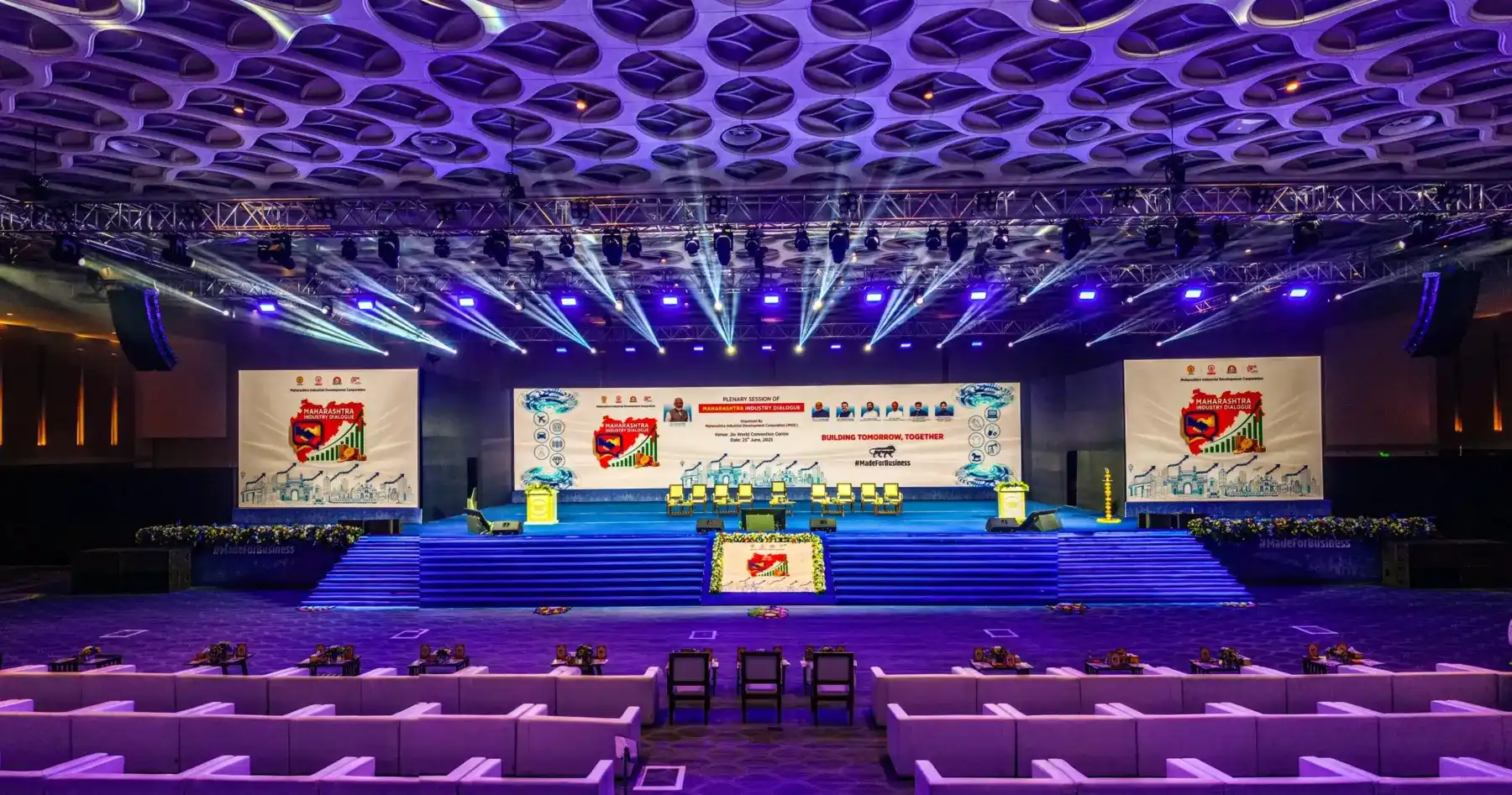 A conference hall stage lit in blue and violet