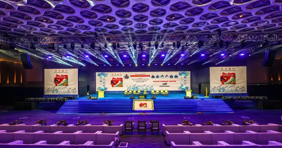 A conference hall stage lit in blue and violet
