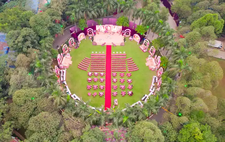 Aerial view of an outdoor wedding venue with a floral stage and seating