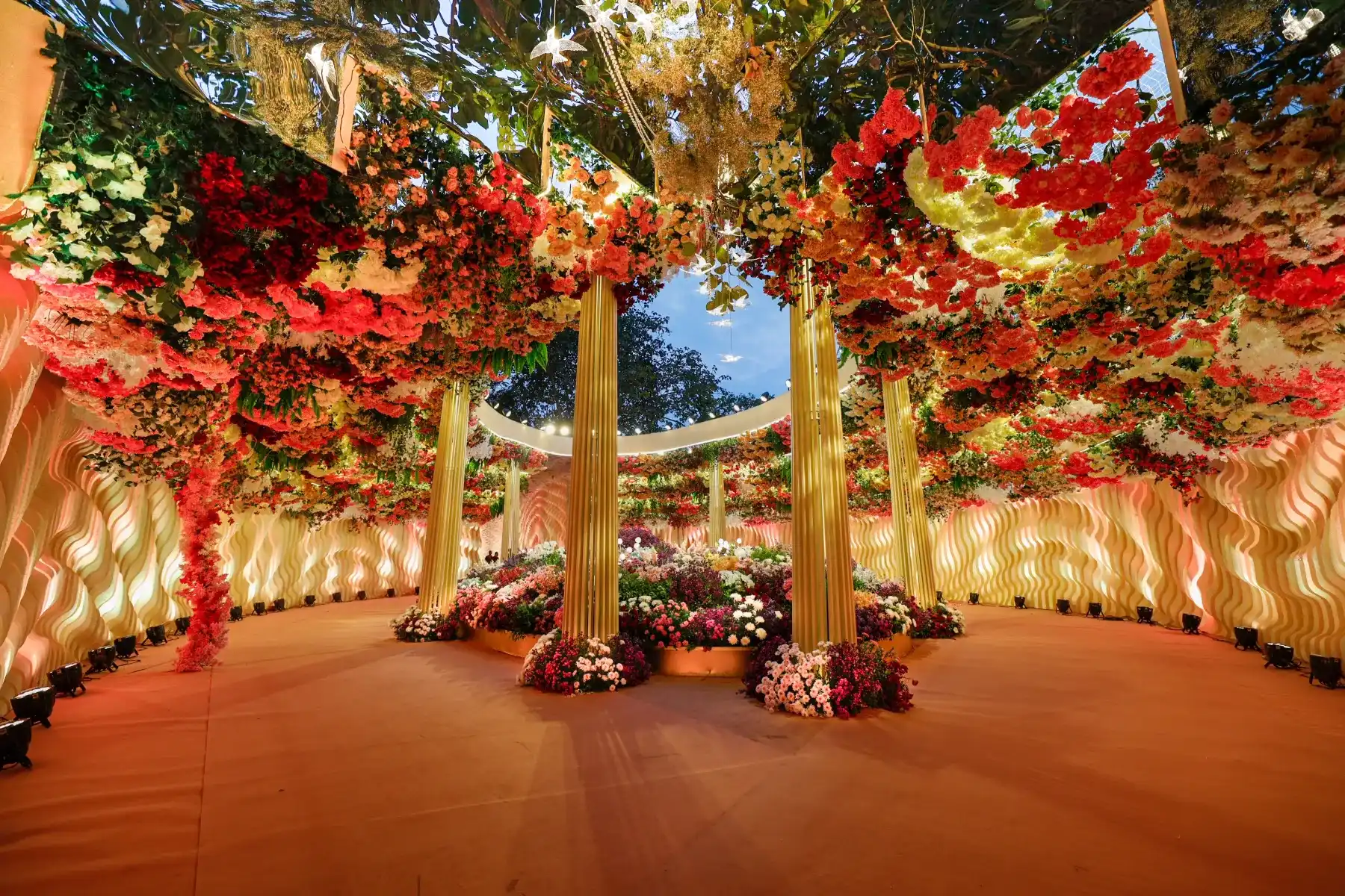 A floral entrance archway with gold pillars and red blooms