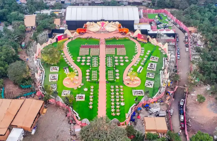 Aerial view of an open air wedding venue with green lawns, a long aisle and a sculpted stage